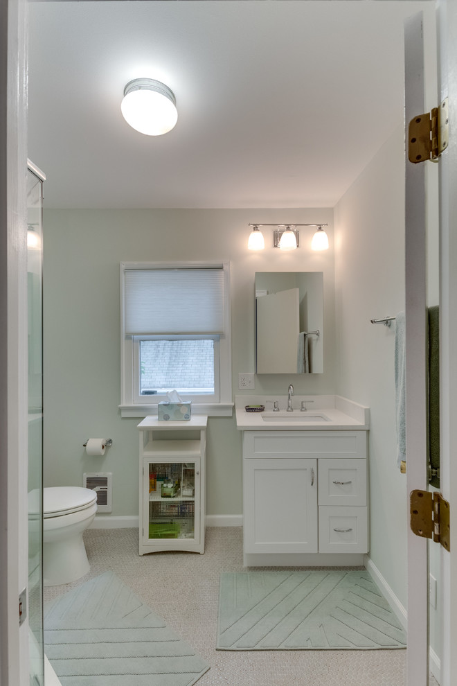Идея дизайна: ванная комната среднего размера в современном стиле с фасадами островного типа, белыми фасадами, угловым душем, раздельным унитазом, серой плиткой, зеленой плиткой, стеклянной плиткой, зелеными стенами, душевой кабиной, врезной раковиной, столешницей из искусственного камня, бежевым полом и душем с распашными дверями