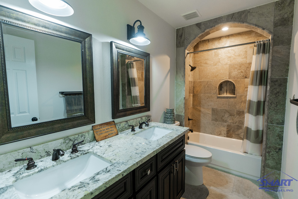 Drop-in bathtub - mid-sized transitional master beige tile and porcelain tile porcelain tile, beige floor, double-sink, coffered ceiling and wainscoting drop-in bathtub idea in Houston with dark wood cabinets, granite countertops, raised-panel cabinets, a one-piece toilet, white walls, an undermount sink, multicolored countertops and a built-in vanity