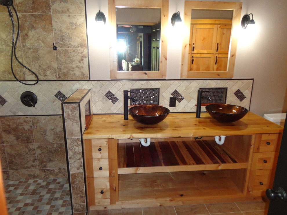 Example of a mid-sized mountain style master beige tile and porcelain tile porcelain tile doorless shower design in Oklahoma City with a vessel sink, light wood cabinets, wood countertops, a two-piece toilet and beige walls