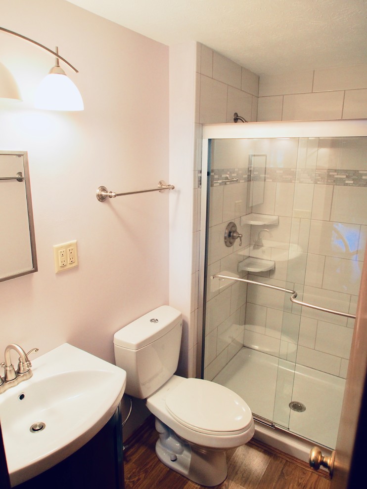Idéer för ett litet klassiskt vit badrum med dusch, med vita skåp, en toalettstol med separat cisternkåpa, vit kakel, porslinskakel, laminatgolv, marmorbänkskiva, brunt golv och dusch med skjutdörr
