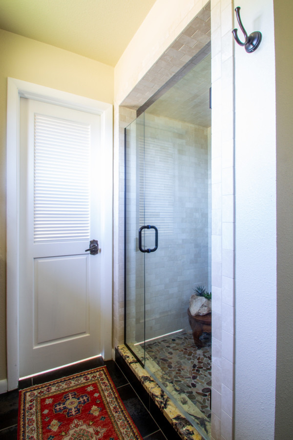 Example of a small transitional master beige tile and subway tile brown floor and slate floor alcove shower design in Denver with medium tone wood cabinets, beige walls, granite countertops, a hinged shower door, multicolored countertops, recessed-panel cabinets and an undermount sink