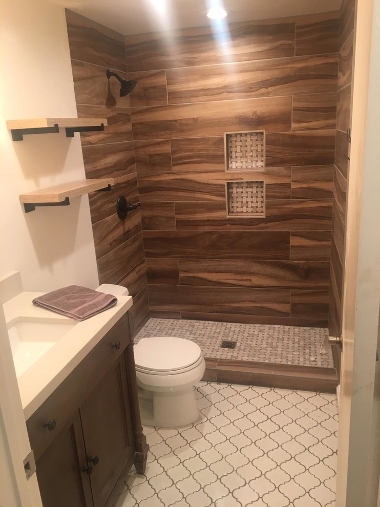 Rustik inredning av ett litet vit vitt badrum med dusch, med skåp i shakerstil, skåp i mörkt trä, en dusch i en alkov, en toalettstol med separat cisternkåpa, brun kakel, porslinskakel, vita väggar, cementgolv, ett undermonterad handfat, bänkskiva i kvarts, vitt golv och med dusch som är öppen