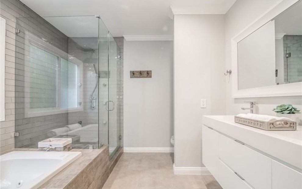Design ideas for a medium sized contemporary ensuite bathroom in Los Angeles with flat-panel cabinets, white cabinets, a built-in bath, a corner shower, grey tiles, metro tiles, grey walls, porcelain flooring, an integrated sink, engineered stone worktops, brown floors, a hinged door and white worktops.
