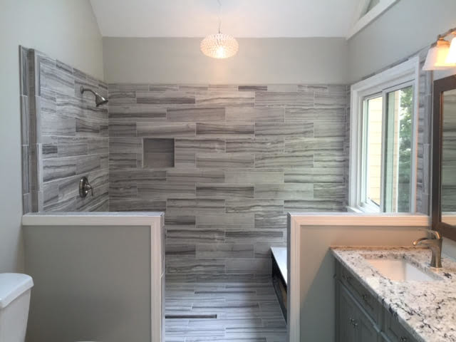 Inredning av ett modernt mellanstort grå grått en-suite badrum, med luckor med infälld panel, grå skåp, grå kakel, porslinskakel, grå väggar, klinkergolv i porslin, ett undermonterad handfat, granitbänkskiva och grått golv