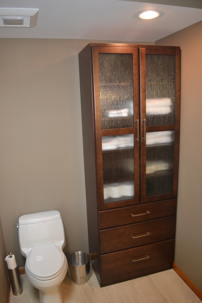 Cette image montre une salle de bain traditionnelle en bois brun avec un lavabo encastré, un placard à porte plane, un plan de toilette en granite, une douche double, WC à poser, un carrelage beige et des carreaux de céramique.