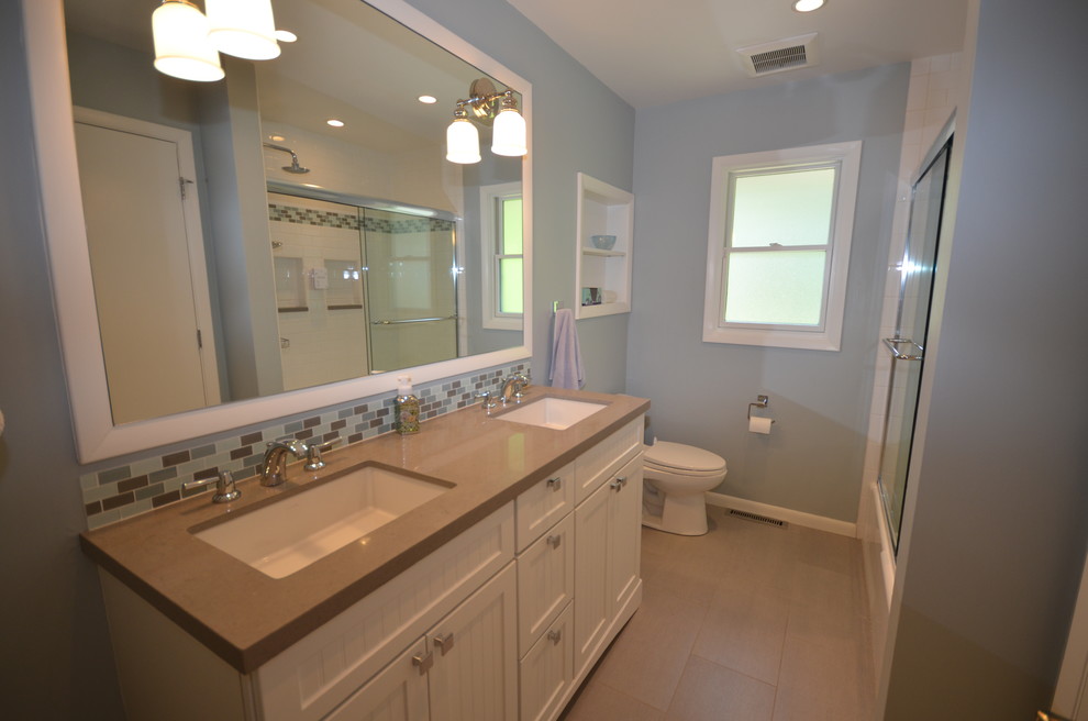 Idéer för amerikanska badrum för barn, med bänkskiva i akrylsten, grå kakel, porslinskakel, blå väggar, klinkergolv i porslin, ett undermonterad handfat och en dusch/badkar-kombination