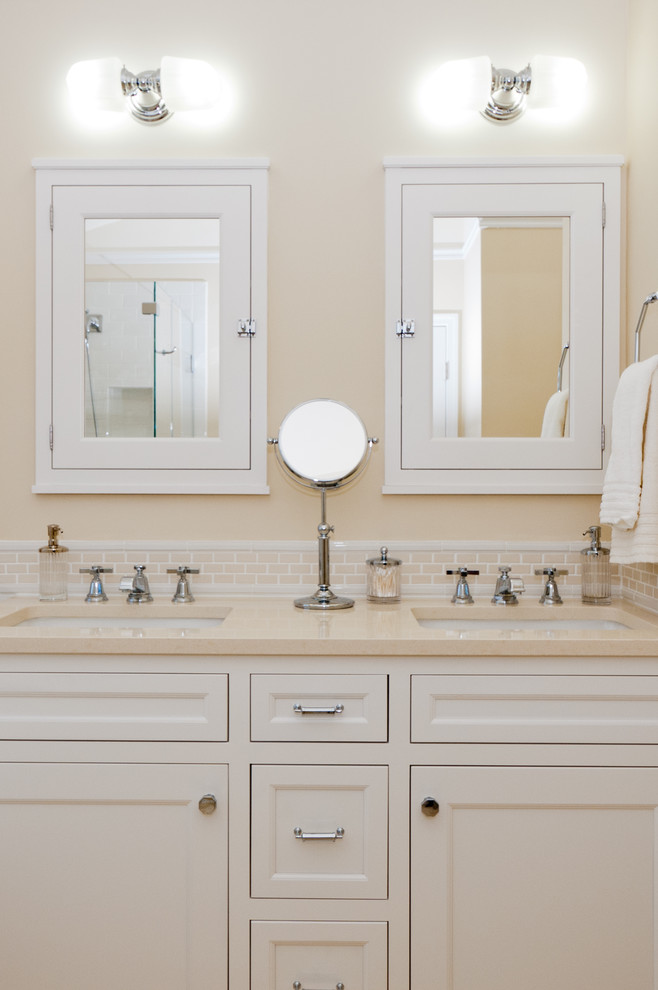 Esempio di una stanza da bagno tradizionale con lavabo sottopiano, ante con riquadro incassato, ante bianche e piastrelle beige