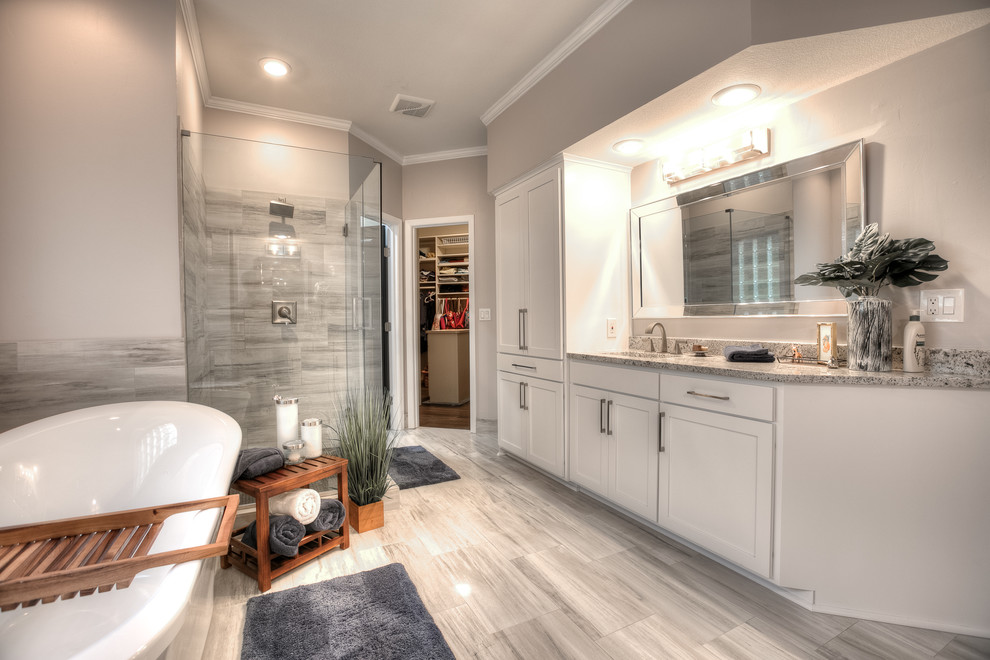 Bathroom - mid-sized traditional master gray tile and porcelain tile porcelain tile and gray floor bathroom idea in Kansas City with recessed-panel cabinets, white cabinets, beige walls, an undermount sink, granite countertops, a hinged shower door and beige countertops