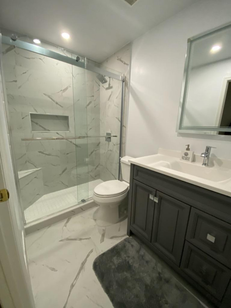 Свежая идея для дизайна: ванная комната среднего размера в стиле неоклассика (современная классика) с фасадами с утопленной филенкой, серыми фасадами, душем в нише, раздельным унитазом, белой плиткой, мраморной плиткой, серыми стенами, мраморным полом, монолитной раковиной, столешницей из искусственного кварца, белым полом, душем с раздвижными дверями, белой столешницей, тумбой под одну раковину и напольной тумбой - отличное фото интерьера