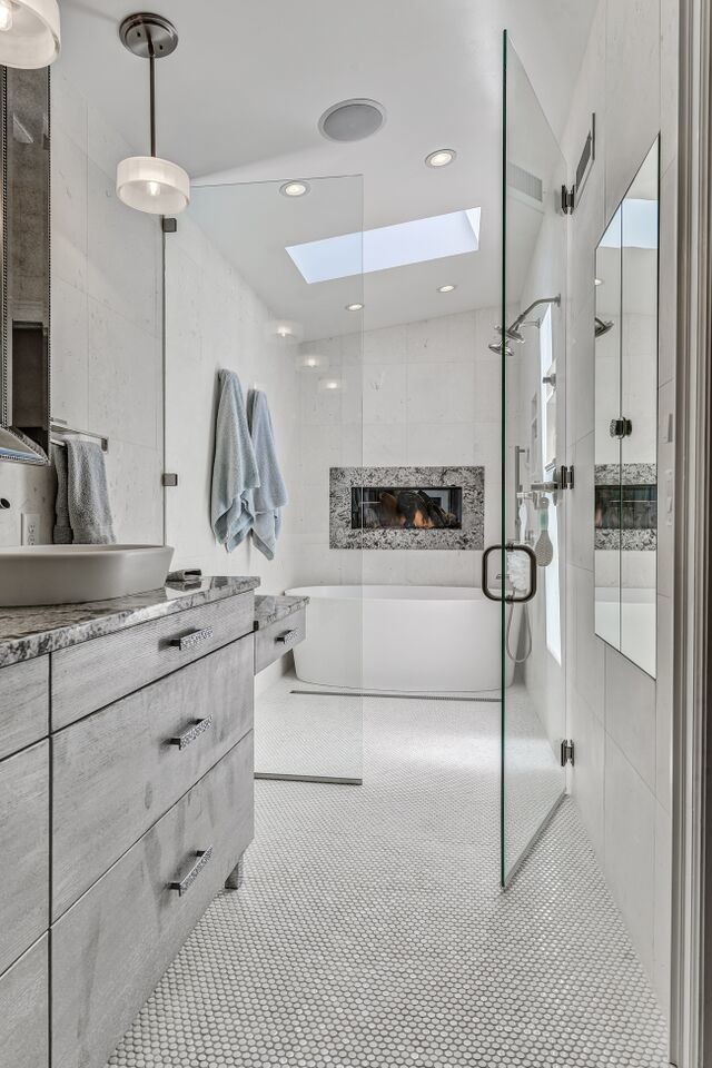 Klassisk inredning av ett mellanstort en-suite badrum, med ett fristående handfat, släta luckor, grå skåp, granitbänkskiva, ett fristående badkar, en öppen dusch, en toalettstol med separat cisternkåpa, vit kakel, vita väggar och mosaikgolv