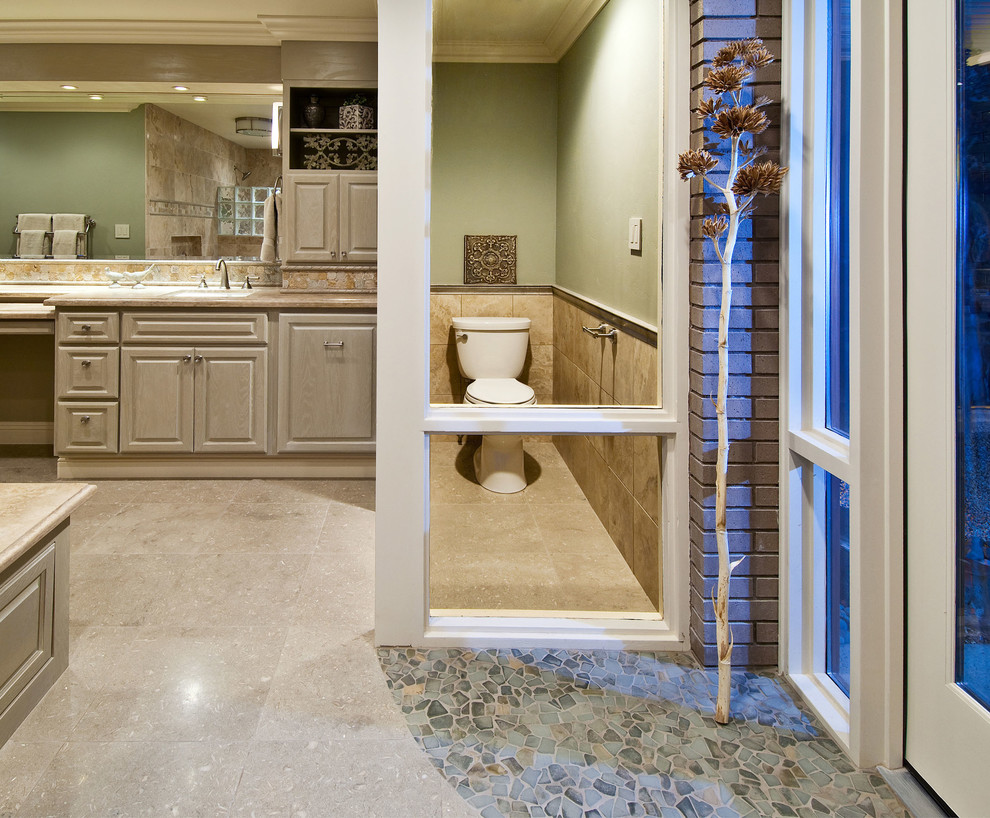 Cette photo montre une salle de bain chic avec un placard avec porte à panneau surélevé, un carrelage beige et des toilettes cachées.