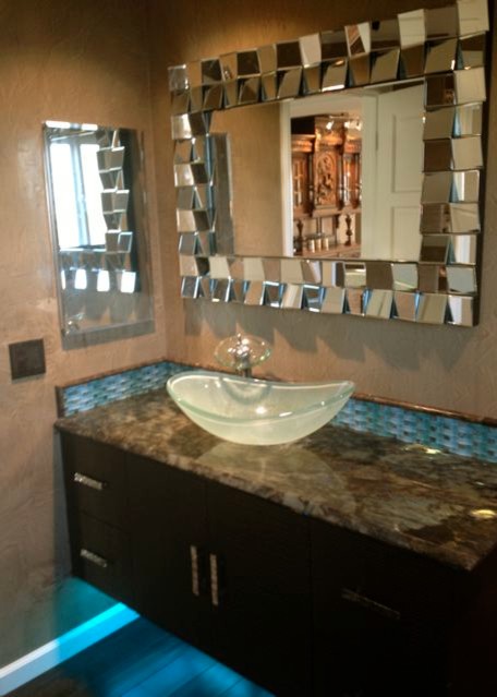 Inredning av ett modernt litet badrum med dusch, med släta luckor, träbänkskiva, blå kakel, glaskakel, ett hörnbadkar, en dusch/badkar-kombination, en toalettstol med hel cisternkåpa, ett fristående handfat, beige väggar och mörkt trägolv