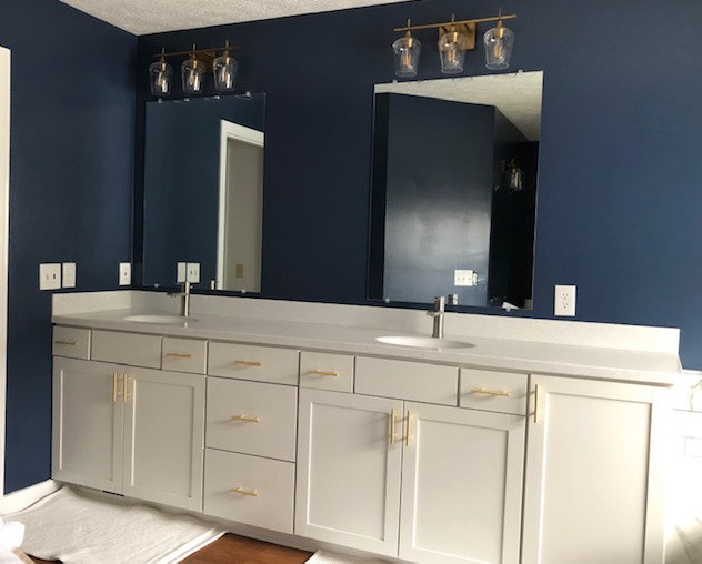 Свежая идея для дизайна: большая главная ванная комната в стиле модернизм с фасадами в стиле шейкер, белыми фасадами, гидромассажной ванной, двойным душем, унитазом-моноблоком, белой плиткой, керамической плиткой, синими стенами, полом из ламината, монолитной раковиной, столешницей из искусственного камня, коричневым полом, открытым душем и разноцветной столешницей - отличное фото интерьера