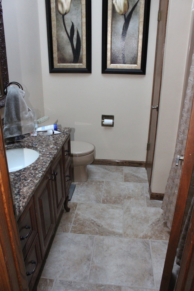 Photo of a traditional ensuite bathroom in Other with a walk-in shower, a one-piece toilet, blue tiles, glass tiles, grey walls, ceramic flooring, an integrated sink and onyx worktops.