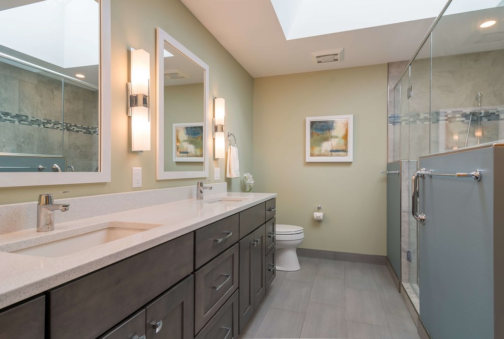 Modern inredning av ett mellanstort en-suite badrum, med luckor med upphöjd panel, skåp i mörkt trä, en kantlös dusch, en toalettstol med hel cisternkåpa, gröna väggar, klinkergolv i keramik, ett undermonterad handfat, granitbänkskiva, grått golv och dusch med gångjärnsdörr