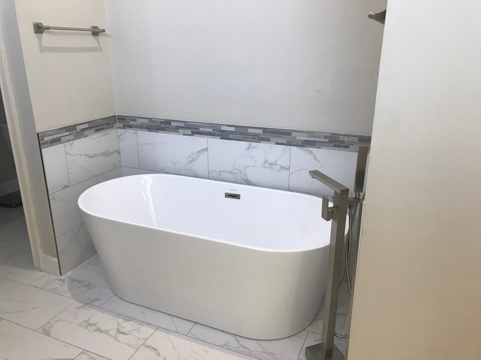 Example of a huge transitional master gray tile and porcelain tile porcelain tile and white floor bathroom design in Jacksonville with shaker cabinets, white cabinets, a two-piece toilet, gray walls, an undermount sink, quartz countertops, a hinged shower door and white countertops