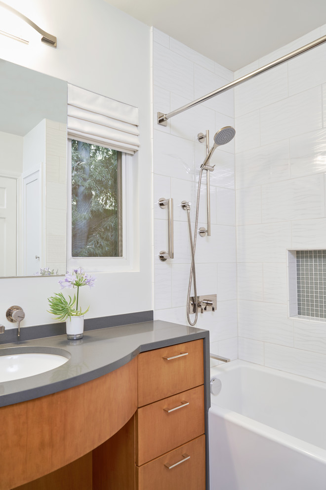 Ejemplo de cuarto de baño principal contemporáneo de tamaño medio con armarios con paneles lisos, puertas de armario de madera en tonos medios, bañera empotrada, ducha con cortina y encimeras negras