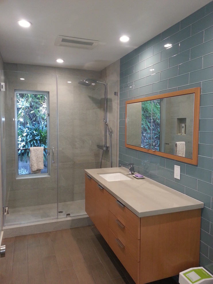 Idées déco pour une salle d'eau moderne en bois clair de taille moyenne avec un placard à porte plane, un plan de toilette en quartz modifié, WC séparés, un carrelage bleu et un carrelage en pâte de verre.
