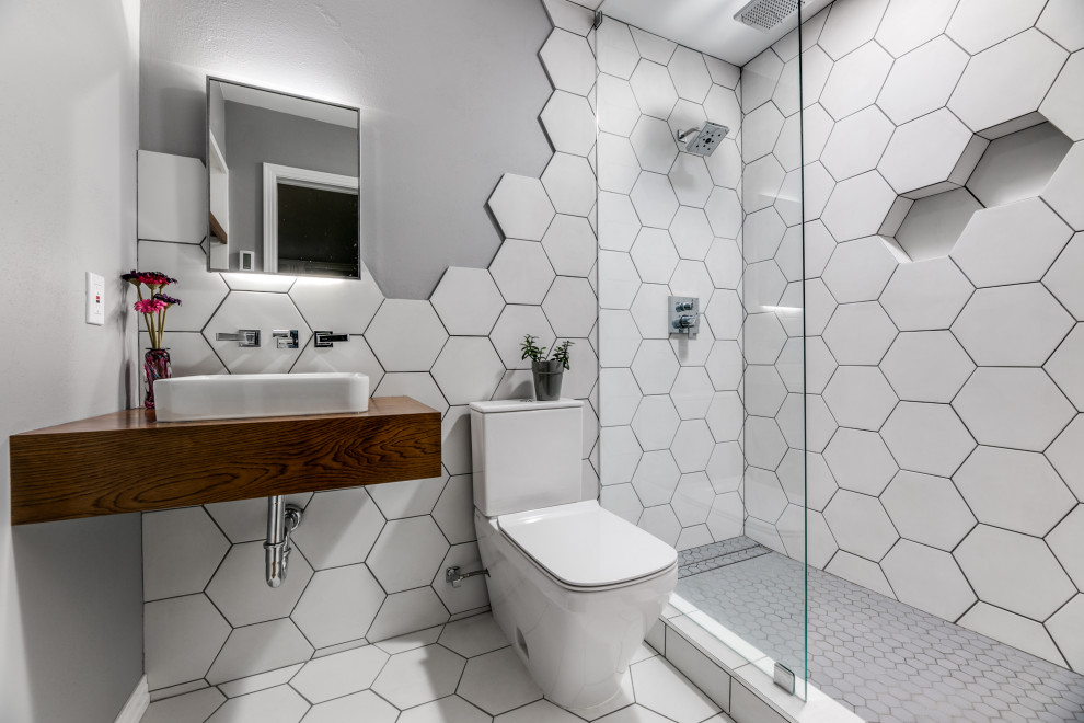 Photo of a medium sized contemporary ensuite bathroom in Dallas with flat-panel cabinets, brown cabinets, a walk-in shower, a two-piece toilet, white tiles, porcelain tiles, grey walls, porcelain flooring, a vessel sink, wooden worktops, white floors, a hinged door, brown worktops, a wall niche, a single sink and a floating vanity unit.