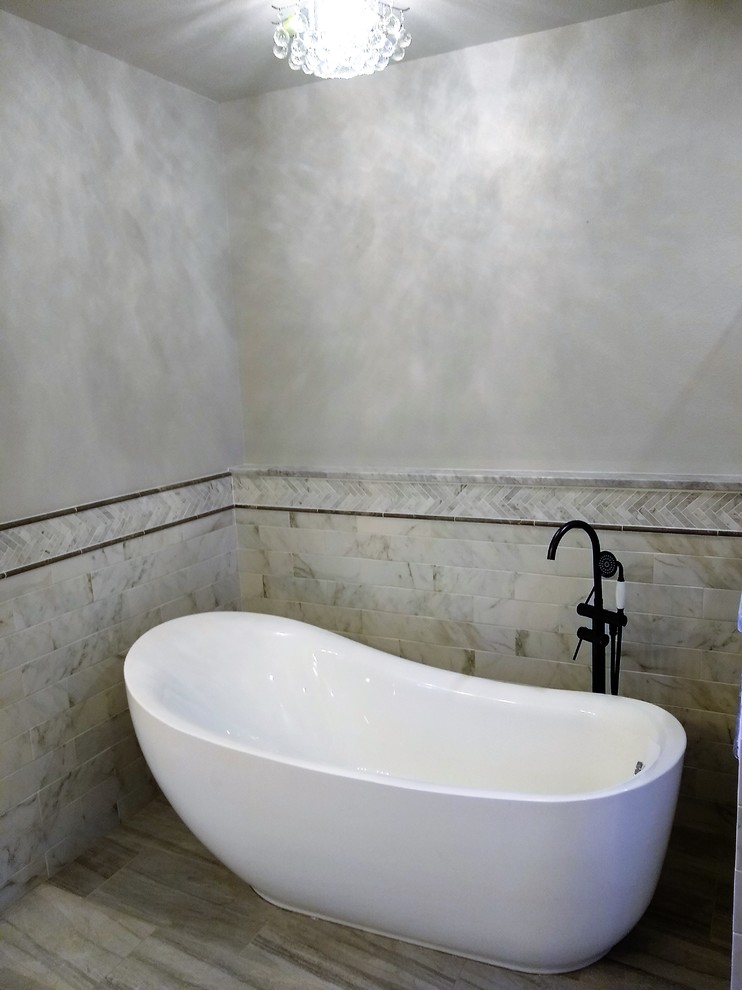 Aménagement d'une grande salle de bain principale campagne avec un placard avec porte à panneau surélevé, des portes de placard grises, une baignoire indépendante, une douche double, WC à poser, un carrelage gris, des carreaux de céramique, un mur gris, un sol en carrelage de céramique, un lavabo encastré, un plan de toilette en marbre, un sol gris, une cabine de douche à porte battante et un plan de toilette gris.