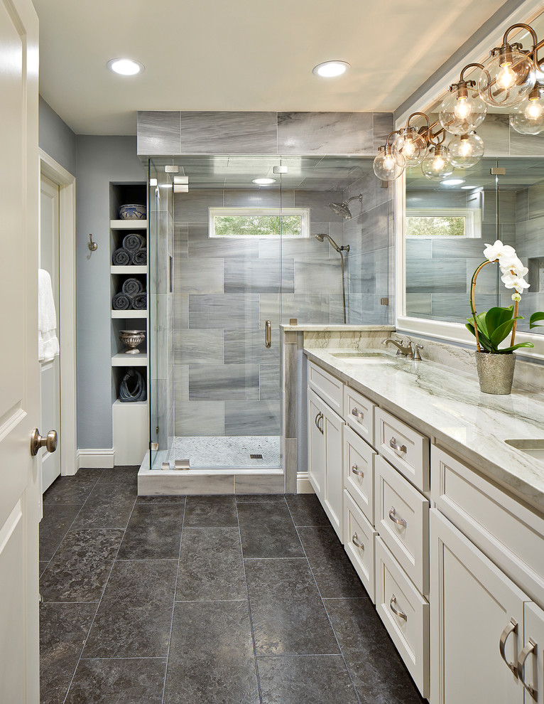 Elegant master gray tile corner shower photo in Dallas with white cabinets, an undermount sink, recessed-panel cabinets and gray walls