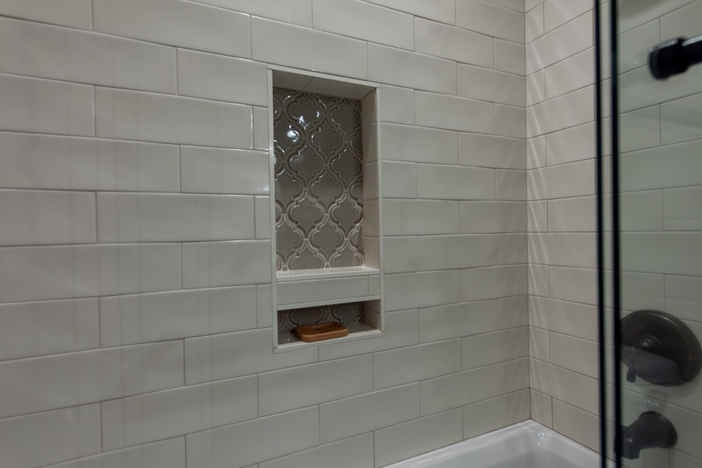 Пример оригинального дизайна: главная ванная комната среднего размера в стиле кантри с фасадами в стиле шейкер, коричневыми фасадами, ванной в нише, душем над ванной, раздельным унитазом, белой плиткой, плиткой кабанчик, бежевыми стенами, полом из керамической плитки, настольной раковиной, столешницей из кварцита, бежевым полом, душем с раздвижными дверями и белой столешницей