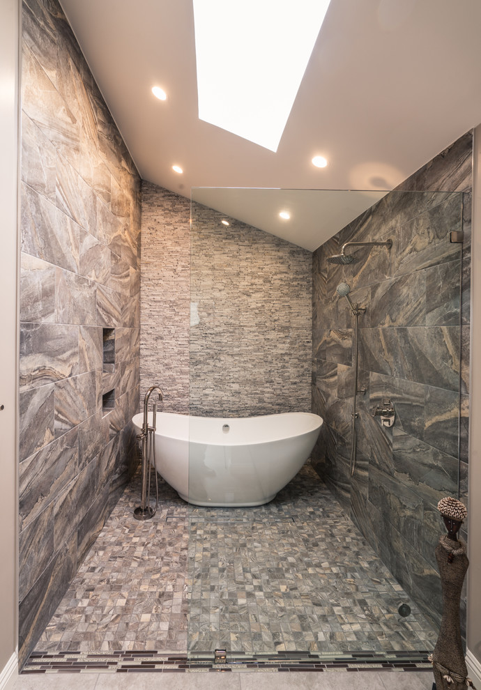 Idée de décoration pour un sauna design en bois brun de taille moyenne avec un placard à porte plane, une baignoire indépendante, WC suspendus, un carrelage gris, un carrelage de pierre, un mur beige, un sol en carrelage de porcelaine, un lavabo intégré et un plan de toilette en granite.