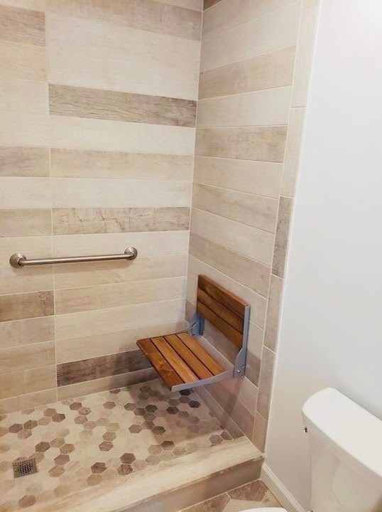 Photo of a medium sized classic shower room bathroom in New York with shaker cabinets, grey cabinets, an alcove shower, beige tiles, brown tiles, a submerged sink, engineered stone worktops, white worktops, a two-piece toilet, stone tiles, beige walls, travertine flooring, multi-coloured floors and a sliding door.