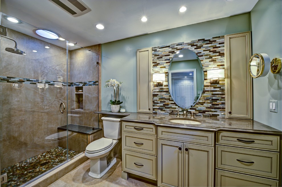 Modern inredning av ett mellanstort en-suite badrum, med ett undermonterad handfat, luckor med infälld panel, beige skåp, granitbänkskiva, en dusch i en alkov, en toalettstol med hel cisternkåpa, flerfärgad kakel och gröna väggar