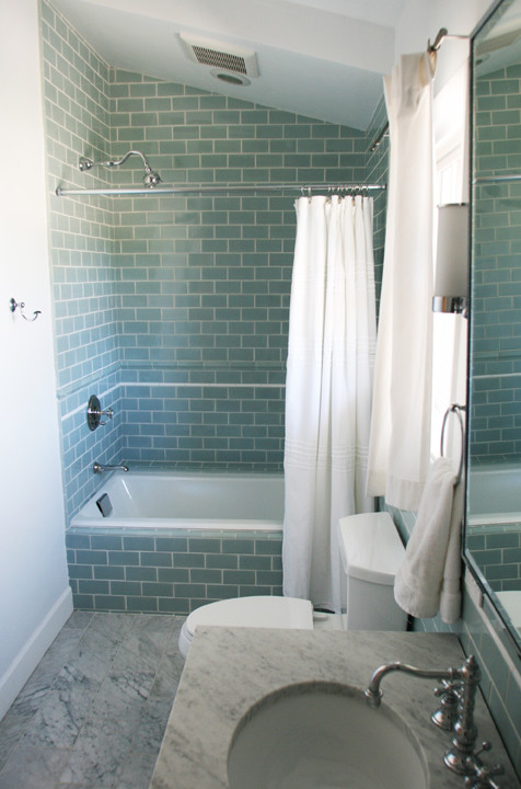 Bild på ett mellanstort vintage badrum, med ett undermonterad handfat, marmorbänkskiva, ett platsbyggt badkar, en dusch/badkar-kombination, en toalettstol med separat cisternkåpa, blå kakel, tunnelbanekakel, grå väggar och marmorgolv