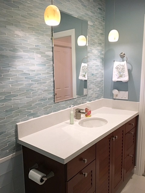 Cette image montre une salle d'eau minimaliste en bois brun de taille moyenne avec un placard à porte persienne, WC séparés, un carrelage bleu, un carrelage en pâte de verre, un sol en carrelage de porcelaine, un lavabo encastré et un plan de toilette en quartz modifié.