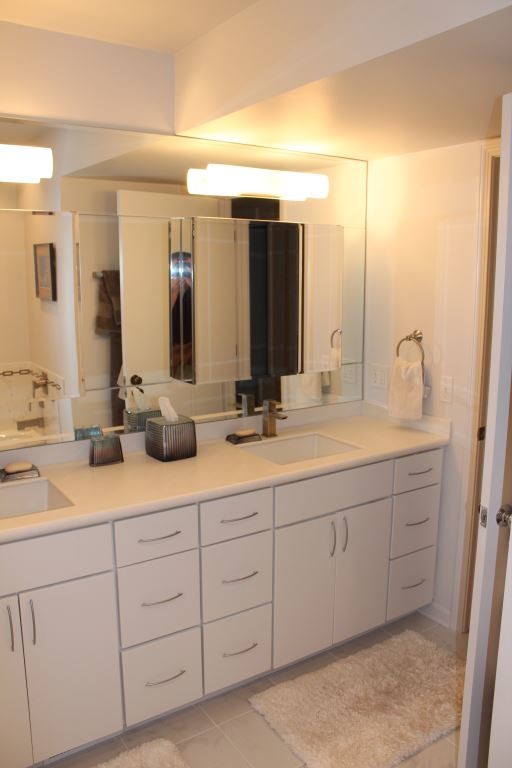 Modelo de cuarto de baño contemporáneo con lavabo bajoencimera, puertas de armario blancas y encimera de acrílico