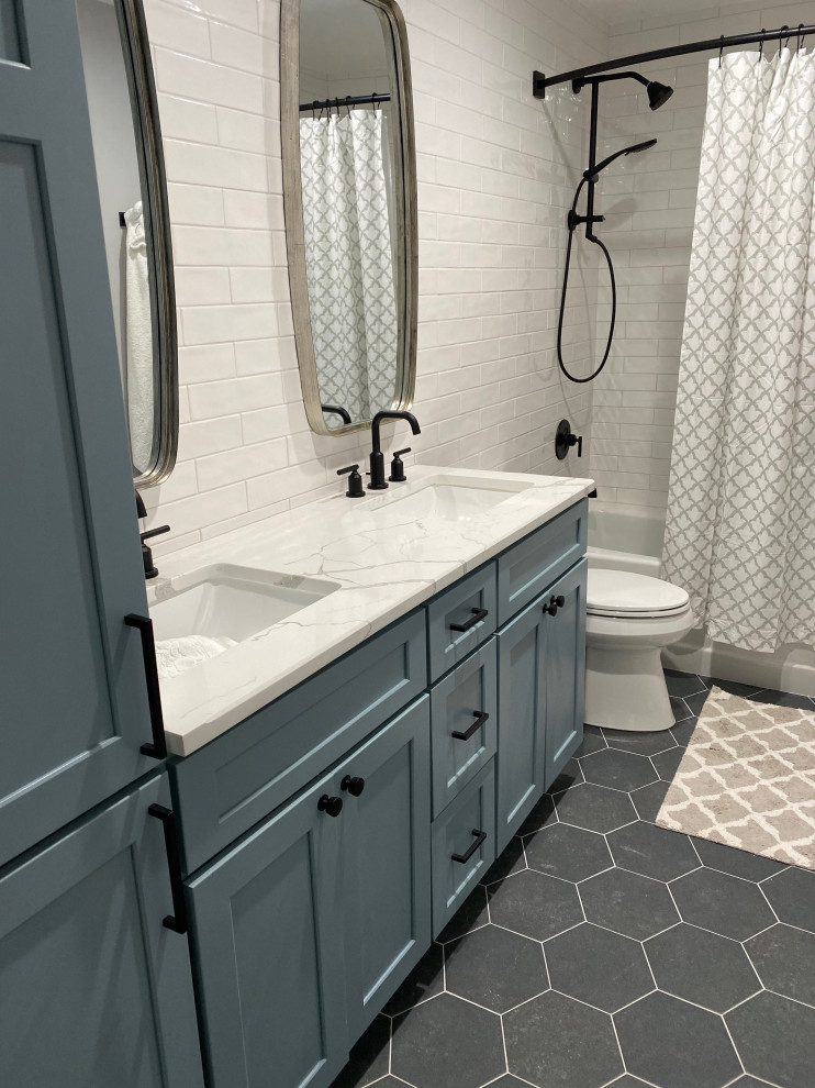 Idéer för ett mellanstort klassiskt vit badrum med dusch, med skåp i shakerstil, blå skåp, ett badkar i en alkov, en dusch/badkar-kombination, en toalettstol med separat cisternkåpa, vit kakel, tunnelbanekakel, vita väggar, klinkergolv i porslin, ett undermonterad handfat, marmorbänkskiva, svart golv och dusch med duschdraperi