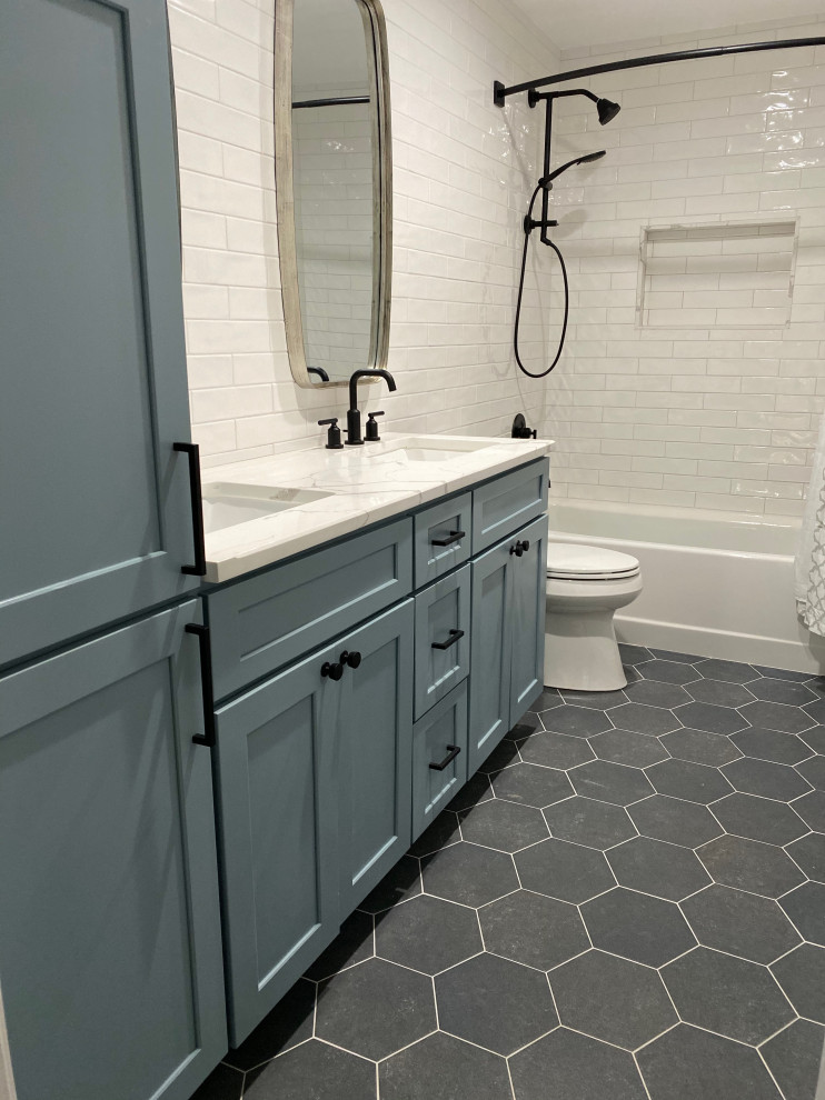 This is an example of a medium sized classic shower room bathroom in New York with shaker cabinets, blue cabinets, an alcove bath, a shower/bath combination, a two-piece toilet, white tiles, metro tiles, white walls, porcelain flooring, a submerged sink, marble worktops, black floors, a shower curtain and white worktops.