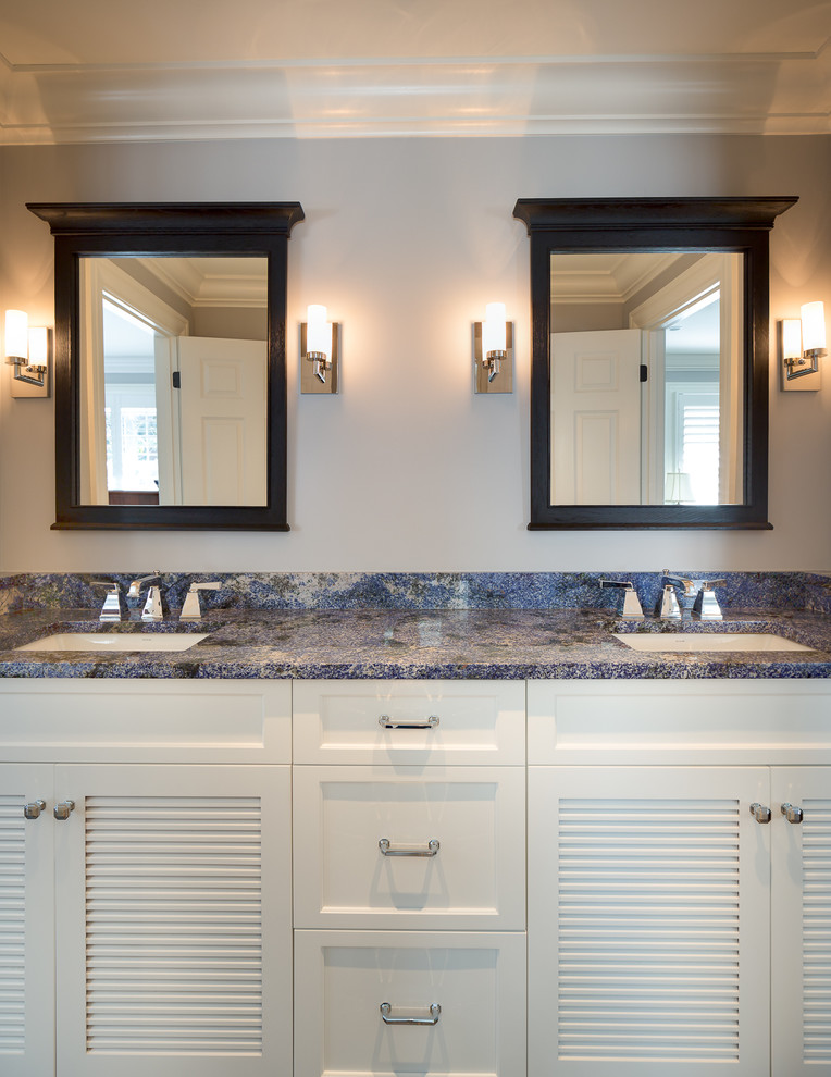 Cette image montre une douche en alcôve traditionnelle de taille moyenne avec un lavabo encastré, un placard à porte persienne, des portes de placard blanches, un plan de toilette en granite, WC à poser, un carrelage gris, un carrelage de pierre et un sol en calcaire.