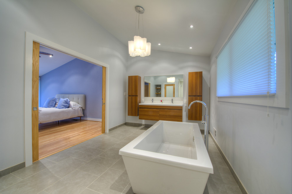 Cette photo montre une salle de bain principale asiatique en bois brun avec un lavabo suspendu, un placard à porte plane, une baignoire indépendante, une douche ouverte, WC suspendus, un carrelage gris et un mur gris.