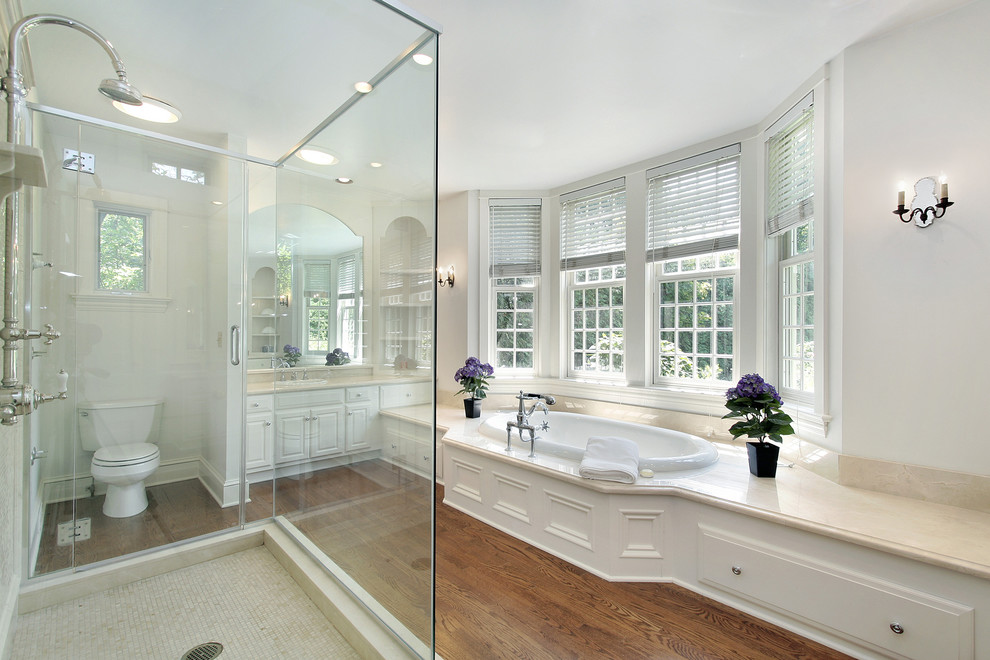 Klassisk inredning av ett stort en-suite badrum, med skåp i shakerstil, vita skåp, en jacuzzi, en öppen dusch, en bidé, beige kakel, mosaik, vita väggar, mörkt trägolv, ett nedsänkt handfat och marmorbänkskiva