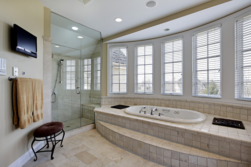 Diseño de cuarto de baño principal clásico grande con jacuzzi, ducha esquinera, baldosas y/o azulejos beige, baldosas y/o azulejos de piedra, paredes beige y suelo de baldosas de cerámica