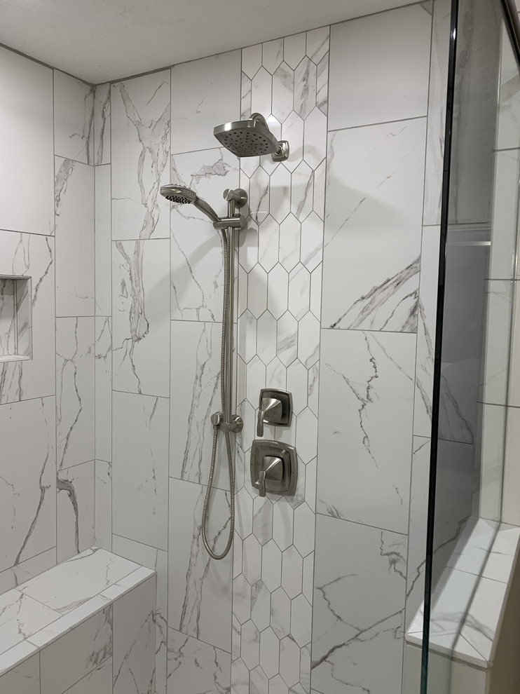 Example of a large transitional master ceramic tile and gray floor bathroom design in Other with recessed-panel cabinets, white cabinets, a two-piece toilet, beige walls, an undermount sink, a hinged shower door and multicolored countertops