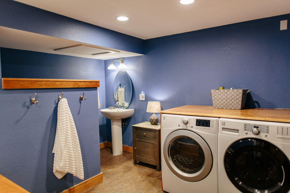 Diseño de cuarto de baño tradicional renovado con bañera encastrada, paredes azules, lavabo con pedestal, suelo beige y tendedero
