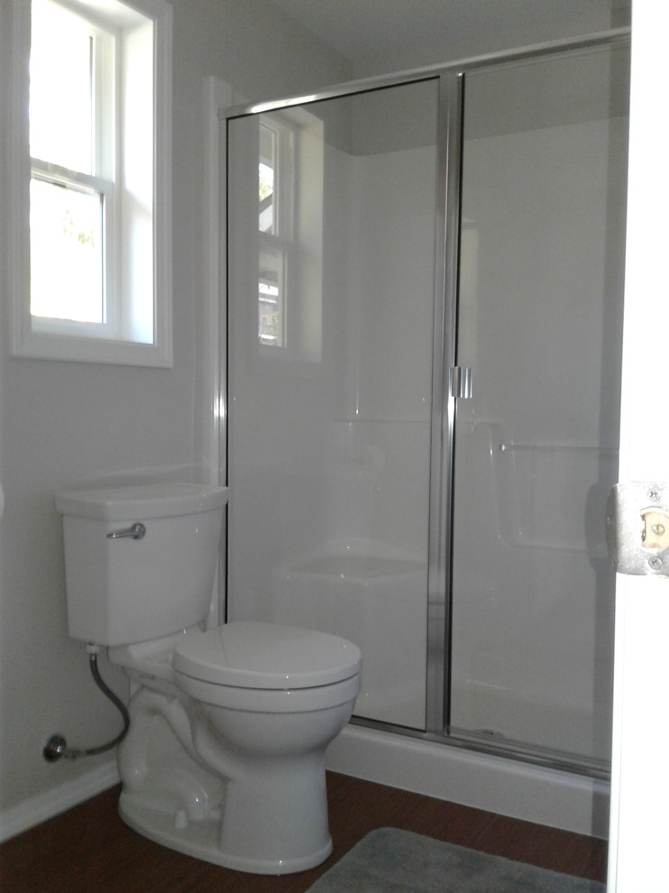 Modern inredning av ett mellanstort en-suite badrum, med ett fristående badkar, en dusch/badkar-kombination, grå kakel, keramikplattor, klinkergolv i småsten, grått golv och dusch med gångjärnsdörr