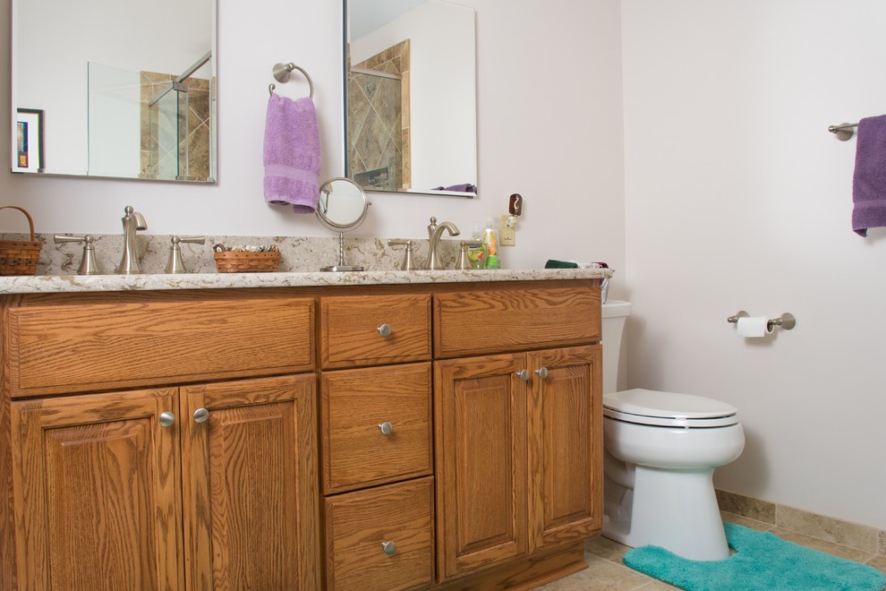 Стильный дизайн: главная ванная комната среднего размера в стиле модернизм с фасадами с выступающей филенкой, коричневыми фасадами, ванной в нише, угловым душем, раздельным унитазом, разноцветной плиткой, керамической плиткой, бежевыми стенами, полом из керамической плитки, накладной раковиной, столешницей из гранита, разноцветным полом и душем с распашными дверями - последний тренд