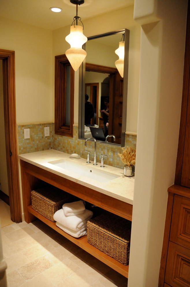 Modelo de cuarto de baño principal moderno de tamaño medio con armarios abiertos, puertas de armario de madera oscura, paredes amarillas, suelo de baldosas de cerámica, lavabo bajoencimera y encimera de acrílico