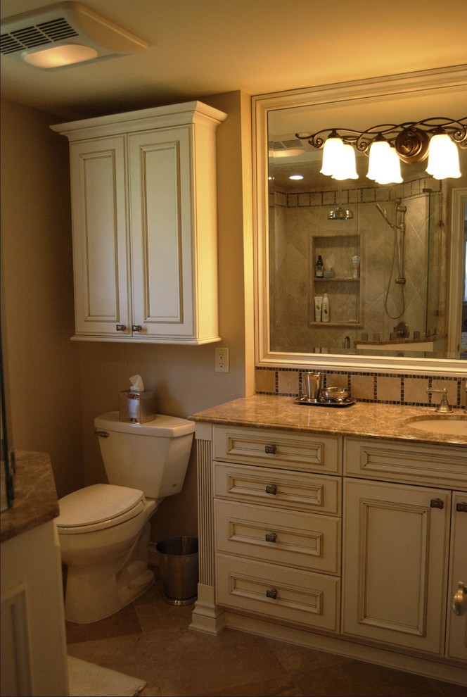 Diseño de cuarto de baño clásico con armarios con paneles empotrados, puertas de armario de madera clara y paredes beige
