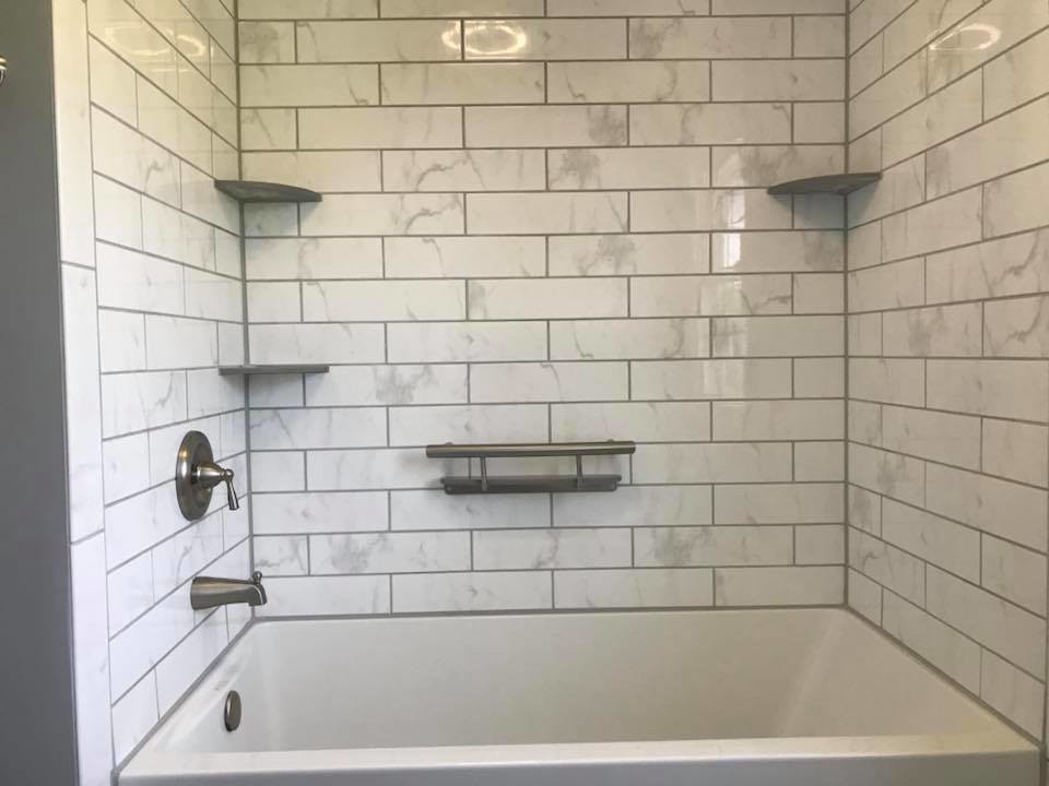 Idéer för att renovera ett mellanstort vintage grå grått badrum med dusch, med luckor med infälld panel, vita skåp, ett badkar i en alkov, en dusch/badkar-kombination, en toalettstol med separat cisternkåpa, vit kakel, porslinskakel, grå väggar, mellanmörkt trägolv, ett undermonterad handfat, bänkskiva i akrylsten, brunt golv och dusch med duschdraperi