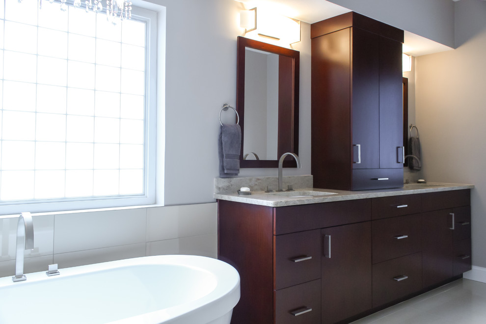 Стильный дизайн: ванная комната в современном стиле с врезной раковиной, плоскими фасадами, темными деревянными фасадами, столешницей из гранита, отдельно стоящей ванной, угловым душем, бежевой плиткой и керамической плиткой - последний тренд