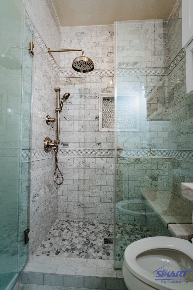 Inredning av ett klassiskt litet vit vitt badrum med dusch, med vita skåp, en toalettstol med hel cisternkåpa, grå kakel, grå väggar, grått golv, dusch med gångjärnsdörr, skåp i shakerstil, en dusch i en alkov, keramikplattor, mosaikgolv, ett undermonterad handfat och marmorbänkskiva