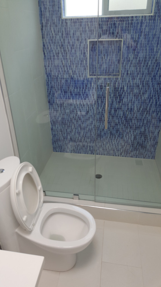 Свежая идея для дизайна: маленькая ванная комната в современном стиле с белыми фасадами, синей плиткой, стеклянной плиткой, белой столешницей и тумбой под одну раковину для на участке и в саду - отличное фото интерьера