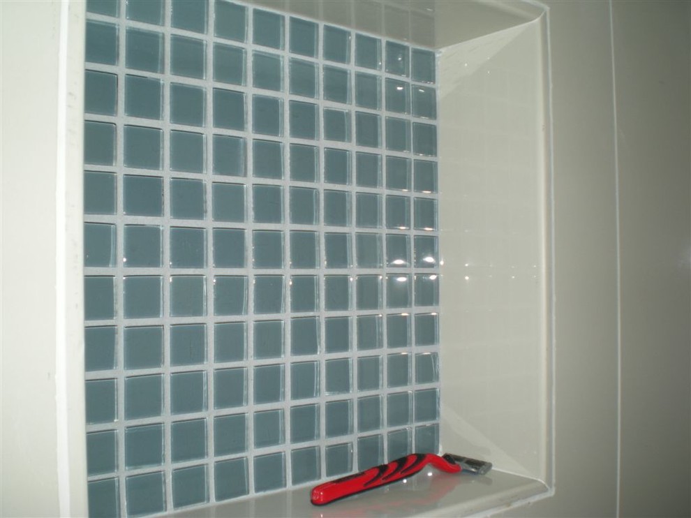 Foto di una stanza da bagno minimalista con ante lisce, ante nere, top in superficie solida, piastrelle bianche, piastrelle in gres porcellanato e pavimento in gres porcellanato