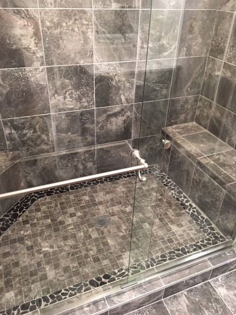 Ispirazione per una stanza da bagno tradizionale con doccia alcova, piastrelle nere, piastrelle in gres porcellanato, pavimento in gres porcellanato, pavimento nero e porta doccia scorrevole